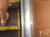 Up2910#Under the skirt of a tanned beauty in a short multi-colored dress. The girl stood wit