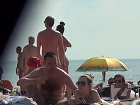 Nu1333#Naked men and women sunbathing on a nudist beach. In the frame gets a beautiful naked