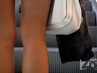 Up2393#Upskirt on an escalator in the mall. Tanned girl in a short red skirt. Our operator w