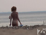 Nu1081#Redhead babe struts along the line of surf and shows her naked body.