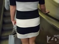 Up2731#Under the skirt of a tanned brunette in a short black and white dress. Beautiful roun