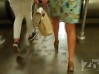 Up2494#Upskirt a tanned girl in a short green dress. Beautiful tanned thighs and shaved crot