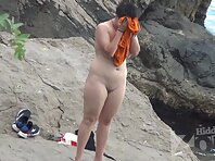 Nu2251#Red-haired beauty sunbathes on the edge of the beach. She has a small but pretty ches